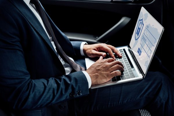 partial-view-of-african-american-businessman-using-laptop-with-internet-security-illustration-in-car.jpg