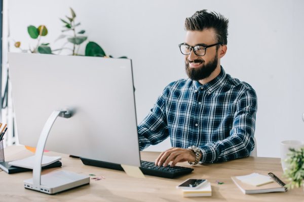 successful-smiling-young-seo-using-computer-at-workplace.jpg